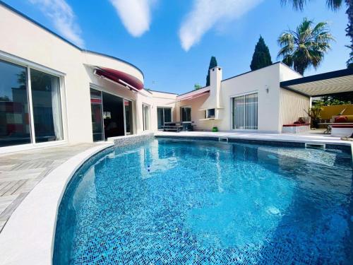 une piscine devant une maison dans l'établissement Villa Occitanie - Villa 6 pers avec piscine quartier résidentiel MAE-4084, à La Grande Motte