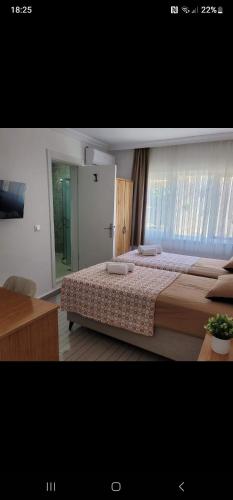 a bedroom with a large bed and a window at OTELIA PANSIYON in Ayvalık
