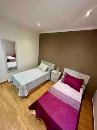 1 dormitorio con 2 camas con sábanas moradas en El Caserón de Hullera, en Cárabanzo