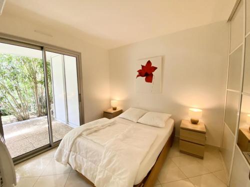 une chambre avec un lit et une grande fenêtre dans l'établissement Eagle - Trois pieces de standing quartier du golf MAE-4094, à La Grande Motte