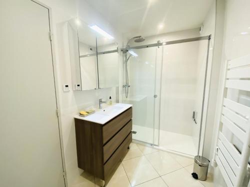 une salle de bain blanche avec un lavabo et une douche dans l'établissement Eagle - Trois pieces de standing quartier du golf MAE-4094, à La Grande Motte