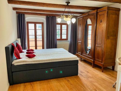 1 dormitorio con 1 cama con almohadas rojas en großzügige Wohnung in der Altstadt mit Balkon, en Görlitz