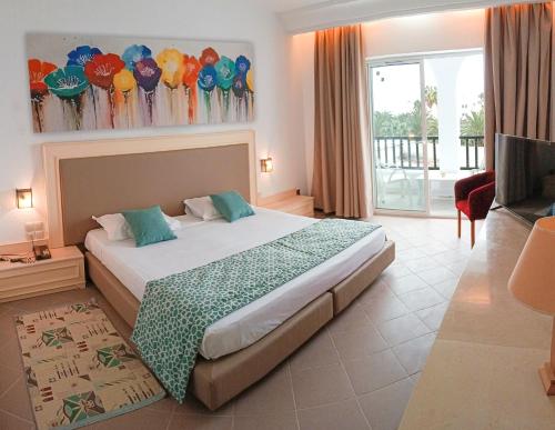 a hotel room with a bed and a television at Monarque El Fatimi Mahdia in Mahdia