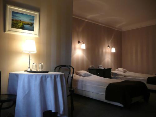 a hotel room with a table and two beds at Leśny Dworek in Wyszków