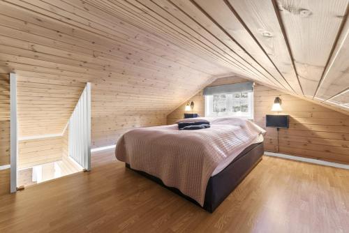 1 dormitorio con cama grande en el techo de madera en Hytte Stryn skisenter, en Stryn