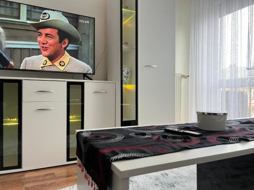 a man in a hat is on a tv screen at APARTAMENT CENTRUM in Nowe Miasto Lubawskie