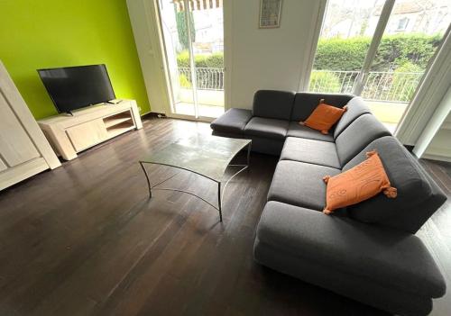 uma sala de estar com um sofá e uma televisão em Rêve cosy - Arceaux * Spacieux F3 * proche tram * wifi * parking em Montpellier