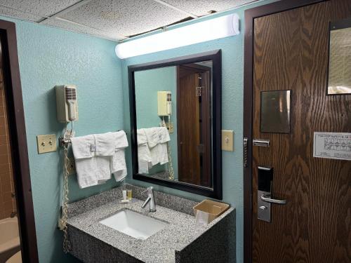W łazience znajduje się umywalka i lustro. w obiekcie Super 8 by Wyndham Blytheville w mieście Blytheville