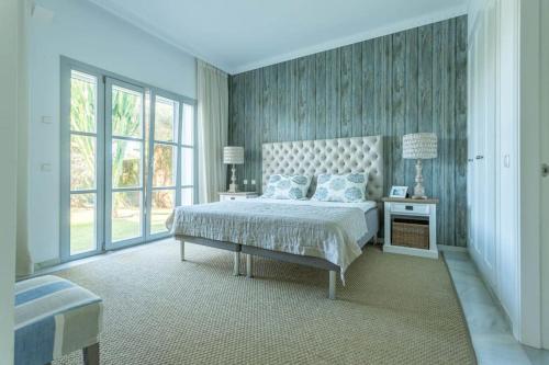 een slaapkamer met een bed en een groot raam bij Villaflair - Marbella Sea View in Marbella
