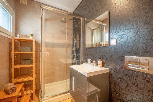 uma casa de banho com um chuveiro, um lavatório e um espelho. em GuestReady - Comfortable Getaway in Sesimbra em Sesimbra