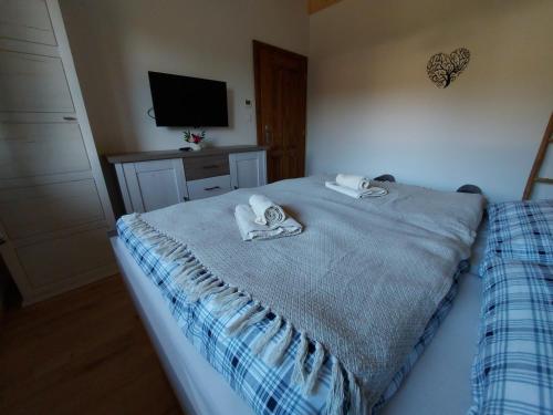 a bedroom with a bed with towels on it at CHALUPY TRI GROŠE VLAŠKY in Bešeňová