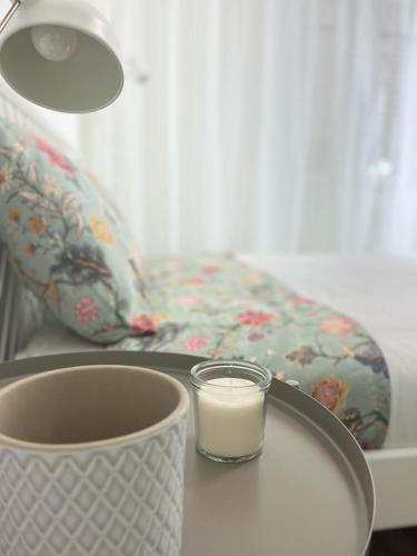 a glass of milk on a table with a candle at Alto Guest room in Lousã