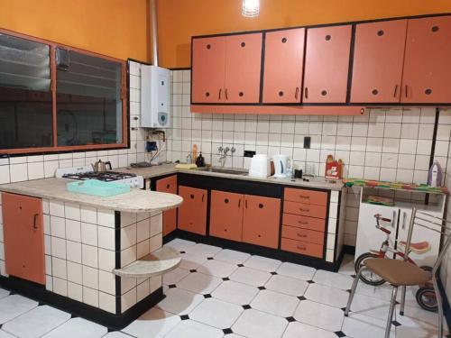 una cucina con armadi rossi e pavimenti piastrellati bianchi di Alquiler temporario en caballito para 6 personas a Buenos Aires