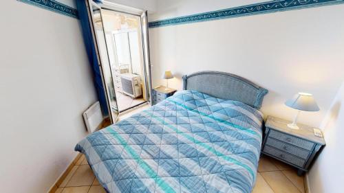 ein kleines Schlafzimmer mit einem Bett und einem Spiegel in der Unterkunft Résidence Victoria Beach - 2 Pièces pour 4 Personnes 954 in Menton