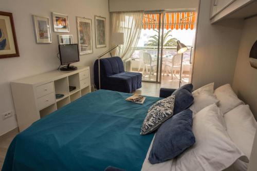 een slaapkamer met een bed met kussens en een stoel bij Résidence Le Diplomat - Studio pour 3 Personnes 894 in Menton
