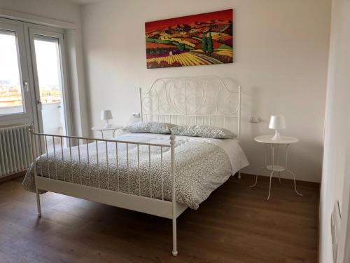 - une chambre avec un lit blanc et une peinture murale dans l'établissement Appartamento vista lago, à Bracciano