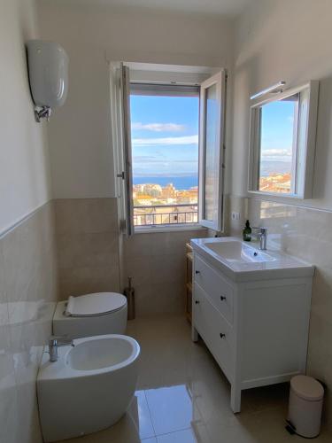 La salle de bains est pourvue d'un lavabo, de toilettes et d'une fenêtre. dans l'établissement Appartamento vista lago, à Bracciano