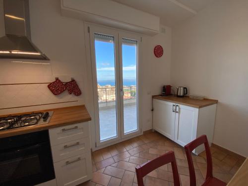 une cuisine avec une grande fenêtre donnant sur l'océan dans l'établissement Appartamento vista lago, à Bracciano