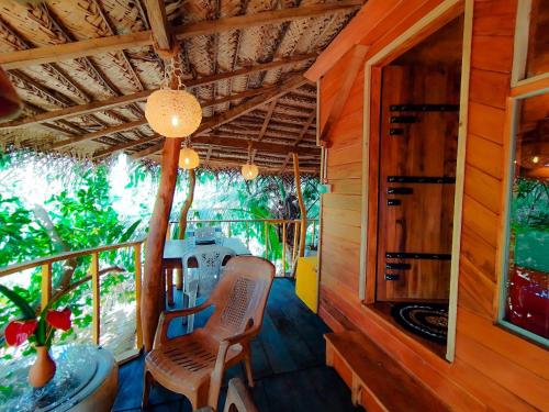 a cabin with a balcony with a table and chairs at The Banda' Eco Villa in Sigiriya