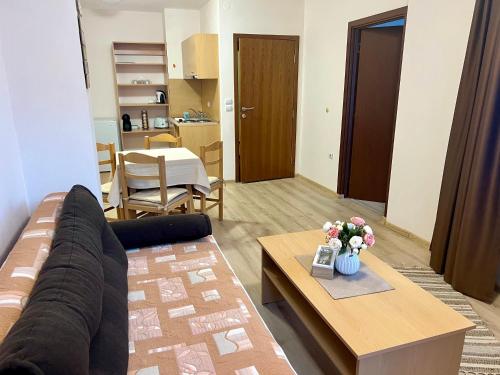 een woonkamer met een bank en een salontafel bij Апартамент Касъл in Pamporovo