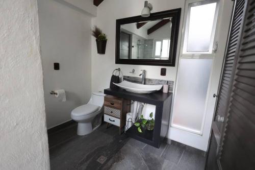 a bathroom with a sink and a toilet and a mirror at Linda casa céntrica c/alberca y jacuzzi in Xochitepec