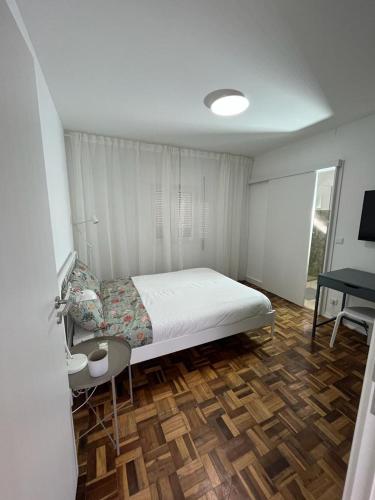 a bedroom with a bed and a desk in it at Alto Guest room in Lousã