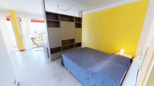 - une chambre avec un lit bleu et un mur jaune dans l'établissement Résidence Le Marly - Studio pour 4 Personnes 344, à Menton