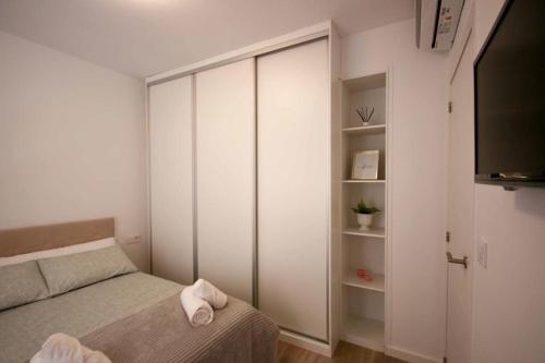a small bedroom with a bed and a tv at Precioso apartamento a 10 min de la playa in Castellón de la Plana