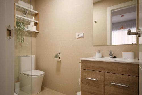 a bathroom with a toilet and a sink and a mirror at Precioso apartamento a 10 min de la playa in Castellón de la Plana