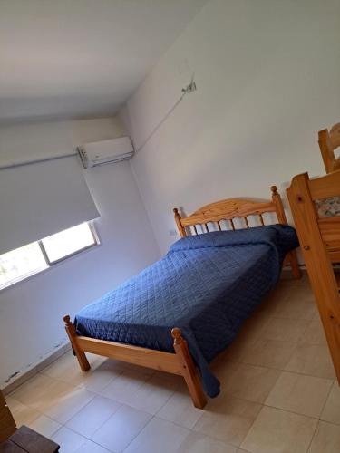 een slaapkamer met een houten bed in een kamer bij LOS CALDENES in Trapiche