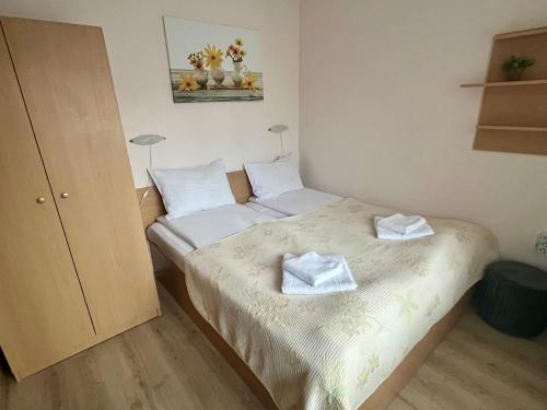 een slaapkamer met 2 bedden en handdoeken bij Апартамент Касъл in Pamporovo