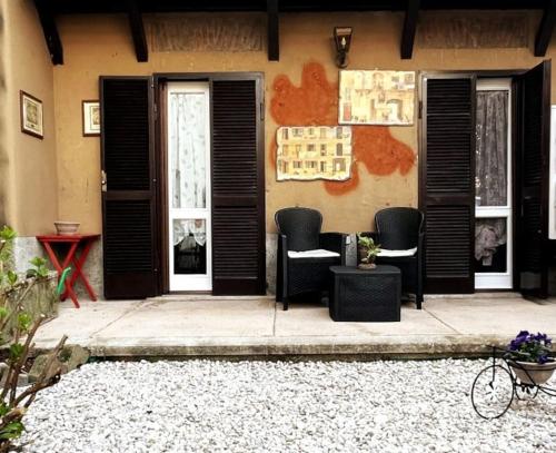 a house with black doors and chairs on a patio at La Casa di Brunina - Serenità a un passo dal Centro in Monza