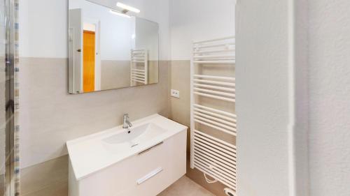 een witte badkamer met een wastafel en een spiegel bij Résidence Hawai - 2 Pièces pour 4 Personnes 644 in Menton