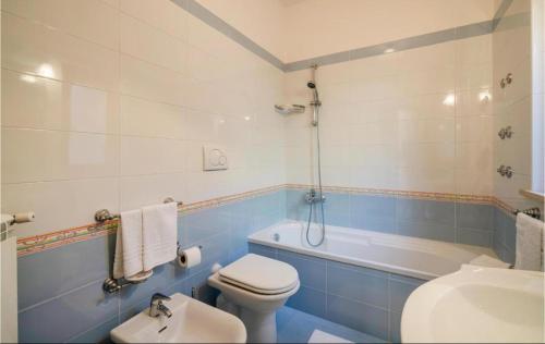 a blue and white bathroom with a toilet and a tub at Villa INARIME in Ischia