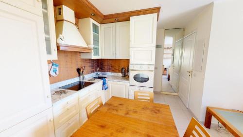 een keuken met witte kasten en een houten tafel bij Résidence Villa Louise - 2 Pièces pour 4 Personnes 584 in Menton