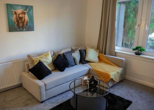 a living room with a couch with pillows and a table at Jacob's Place - rural location in Lanark