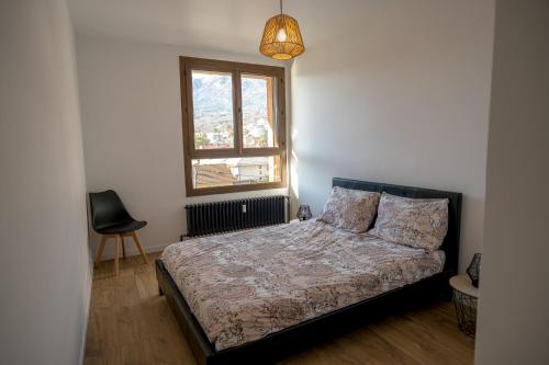 une chambre avec un lit, une fenêtre et une chaise dans l'établissement Appartement vue montagnes, à Gap