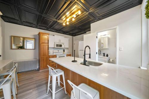 una cocina con armarios blancos y una barra grande con taburetes en CONSHOHOCKEN: Quality & Location, en Conshohocken