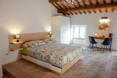 1 dormitorio con 1 cama, mesa y sillas en CASA NINETTA GUEST HOUSE, en Urbisaglia