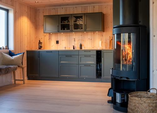 a kitchen with a wood stove in a room at Superior Chalet Sørvågen Lofoten in Sørvågen