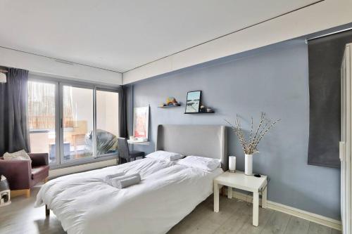 - une chambre avec un grand lit blanc et un mur bleu dans l'établissement Beautiful and bright 3 bed near La Villette, à Paris