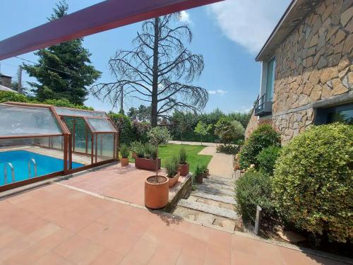 a patio with a swimming pool and a house at Casa Alborada in Cercedilla