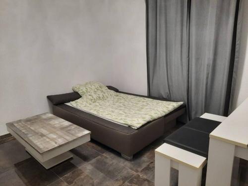 a small bedroom with a bed and a table at Wohnen wie Zuhause in Abstatt