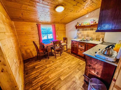 a kitchen with wooden floors and a table and chairs at Ranč Skalka in Rousínov