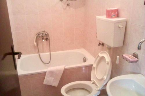a bathroom with a toilet and a bath tub at Restaurant & Apartments JUG in Sutomore