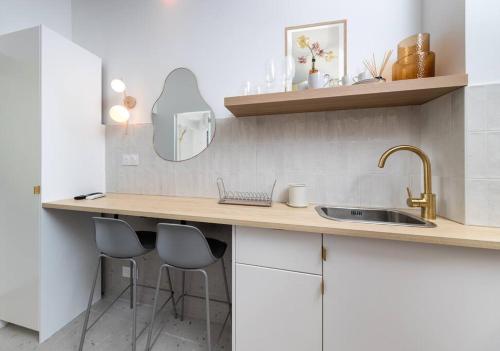 une cuisine avec un comptoir avec deux tabourets et un évier dans l'établissement Unique Old Town Designer Studio, à Nice