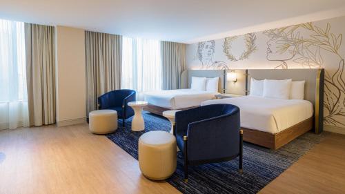 a hotel room with two beds and two chairs at Caesars Atlantic City Hotel & Casino in Atlantic City