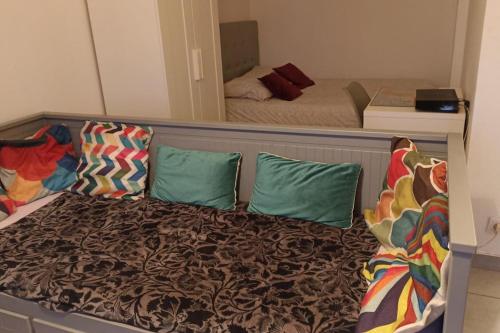 - un lit dans une petite chambre avec un miroir dans l'établissement Parking privé,T1 bis, 10mn Lyon centre, à Villeurbanne