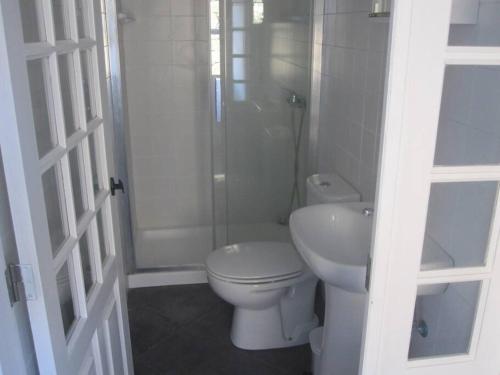 a white bathroom with a toilet and a shower at Casa dos Vimes - mar e céu in São Roque do Pico