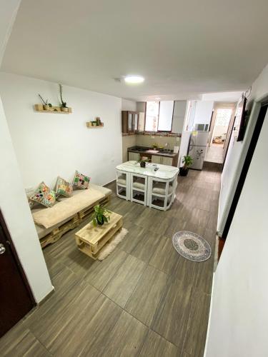 Habitación con baño compartido في بوغوتا: غرفة معيشة مع أريكة وطاولة